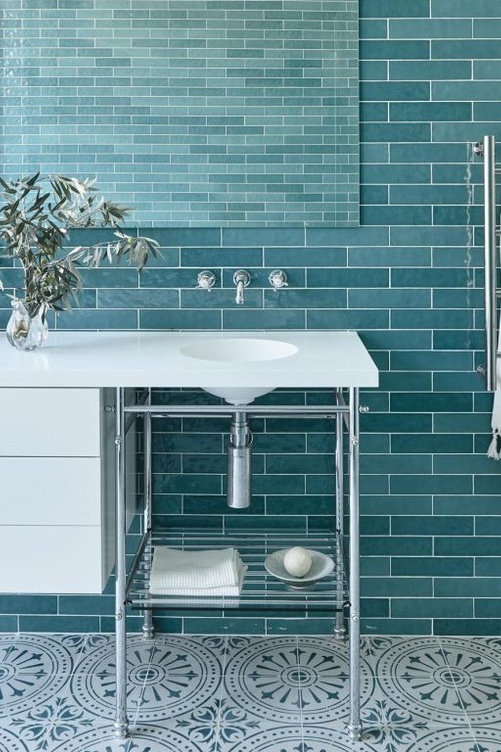 Calming bathroom featuring teal cement tiles and a minimalist design with bright accents.