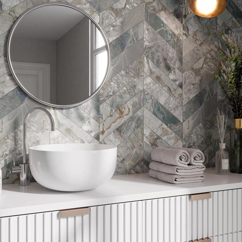 Diseño de baño moderno con azulejos en chevron de piedra natural.