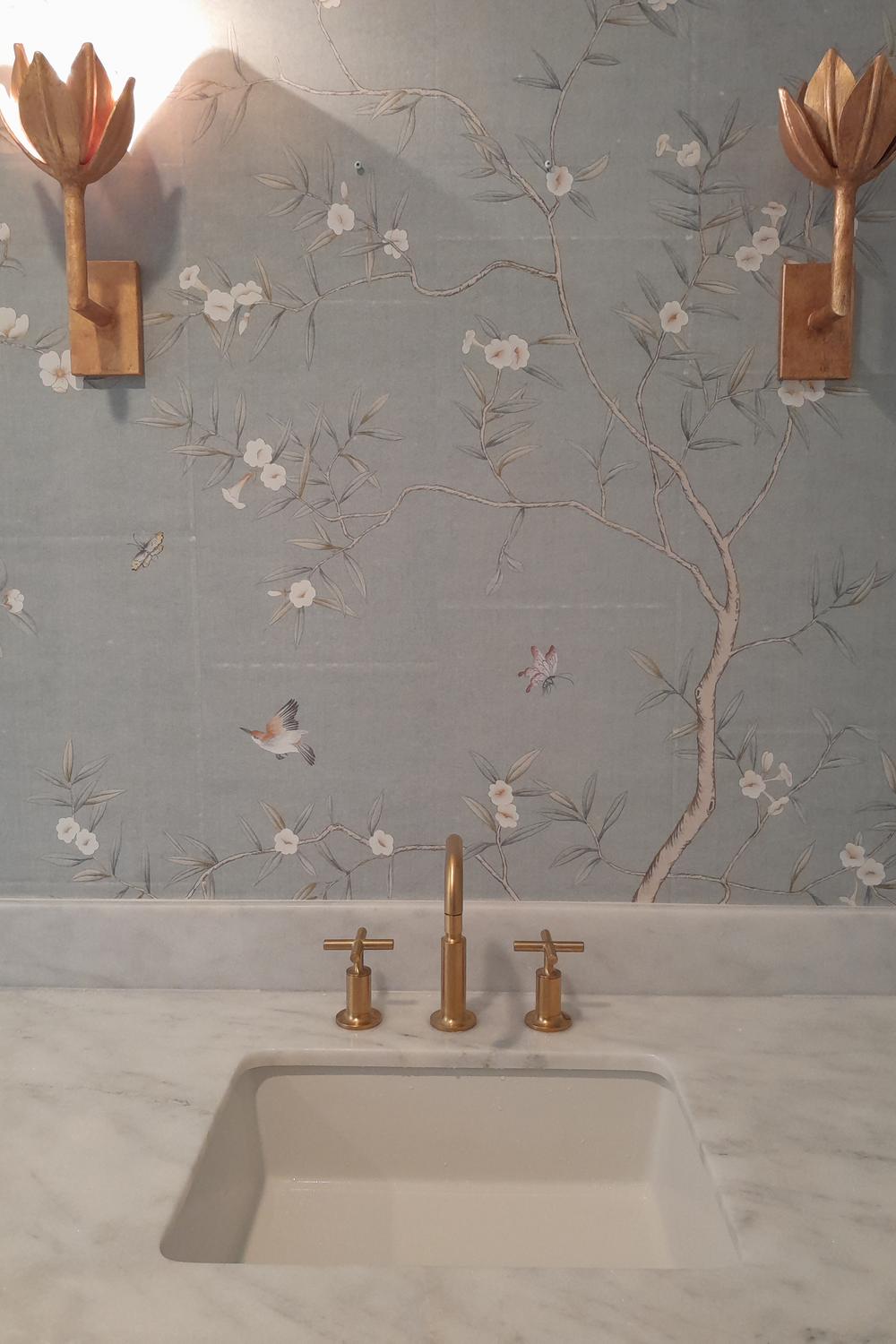 Delicate chinoiserie wallpaper in soothing light blue tones enhances the elegance of a modern bathroom design.