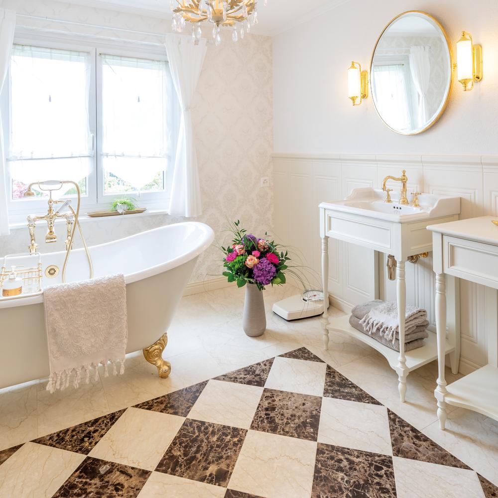 Baño clásico con bañera blanca y detalles en oro