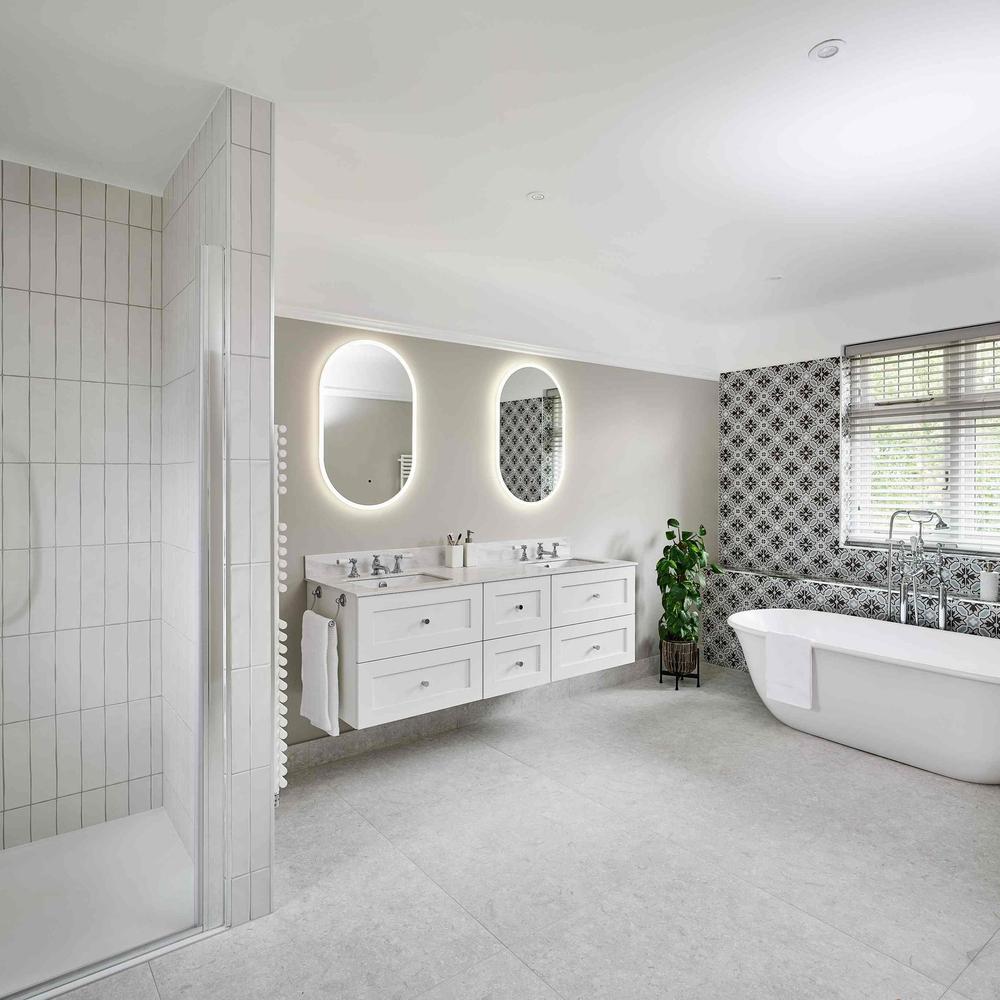 Open-plan bathroom design featuring distinct areas for bathing, vanity, and natural light enhancing the ambience.