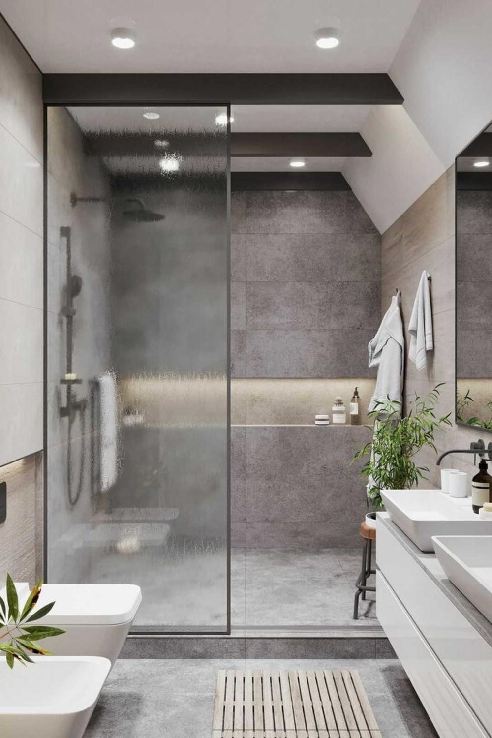 Stylish modern bathroom with a spacious glass shower enclosure highlighting a minimalist design ethos.