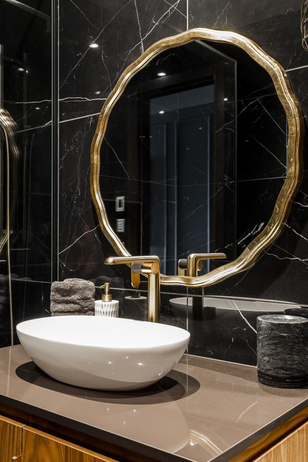 Luxurious bathroom featuring deep black and rich brown tones contrasted with white sink and gold accents for elegance.