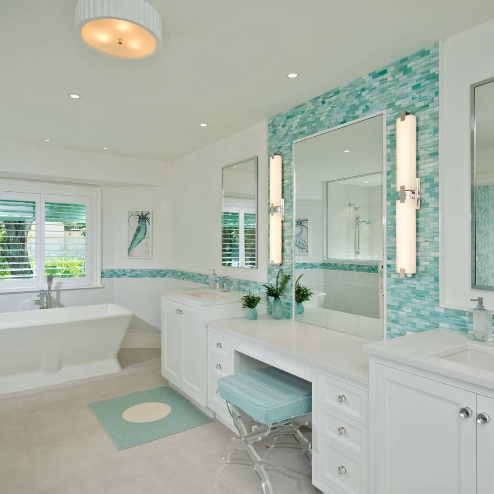 Baño costero luminoso con azulejos en tonos turquesa