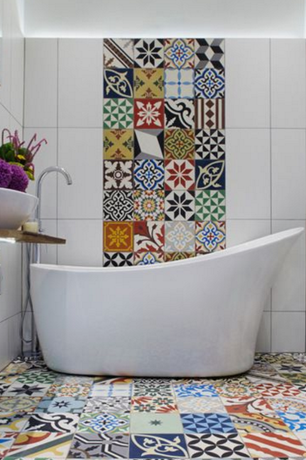 Elegant bathroom featuring floral patterned mosaic tiles and a white freestanding tub.
