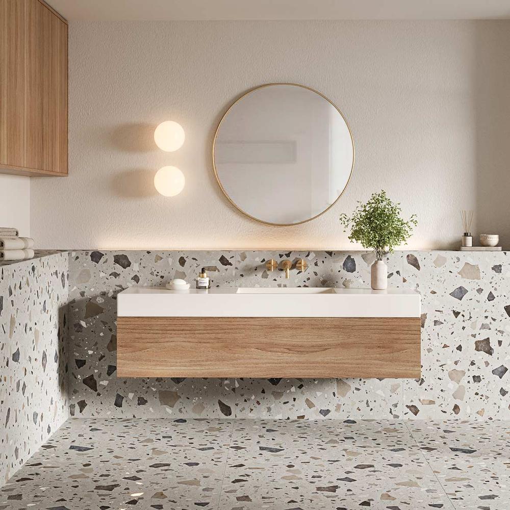 Modern bathroom featuring muted terrazzo tiles with a floating vanity and round mirror.