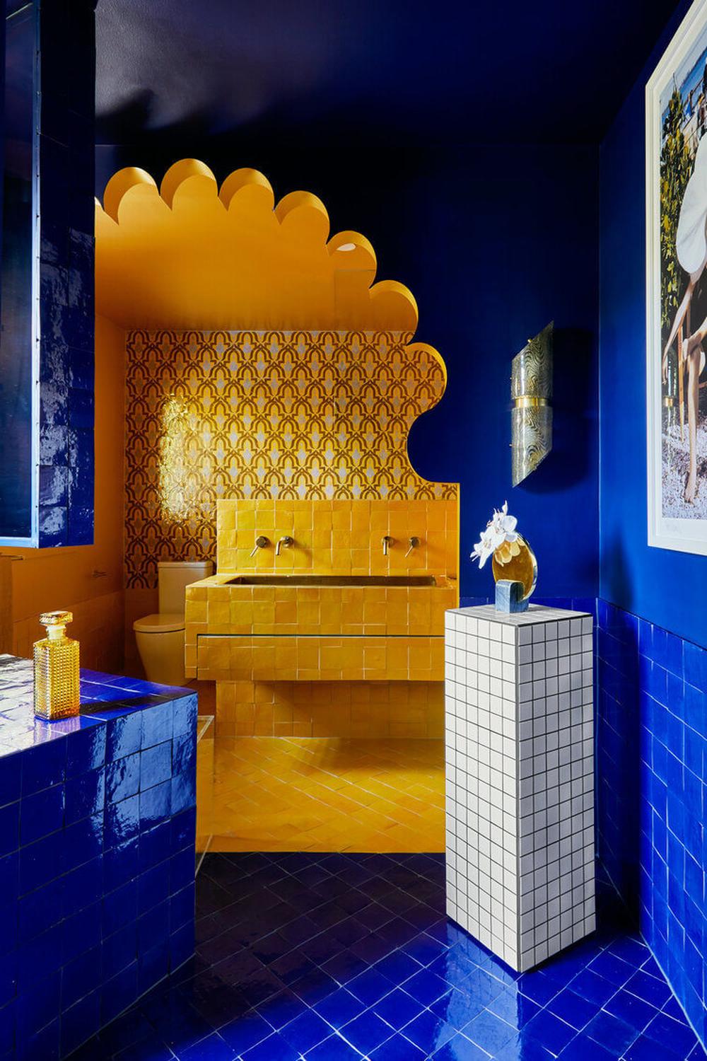 Artistic bathroom design showcasing bold navy blue tiles and sunny yellow accents.