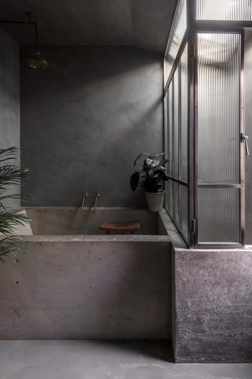 Baño elegante con bañera de hormigón texturizada
