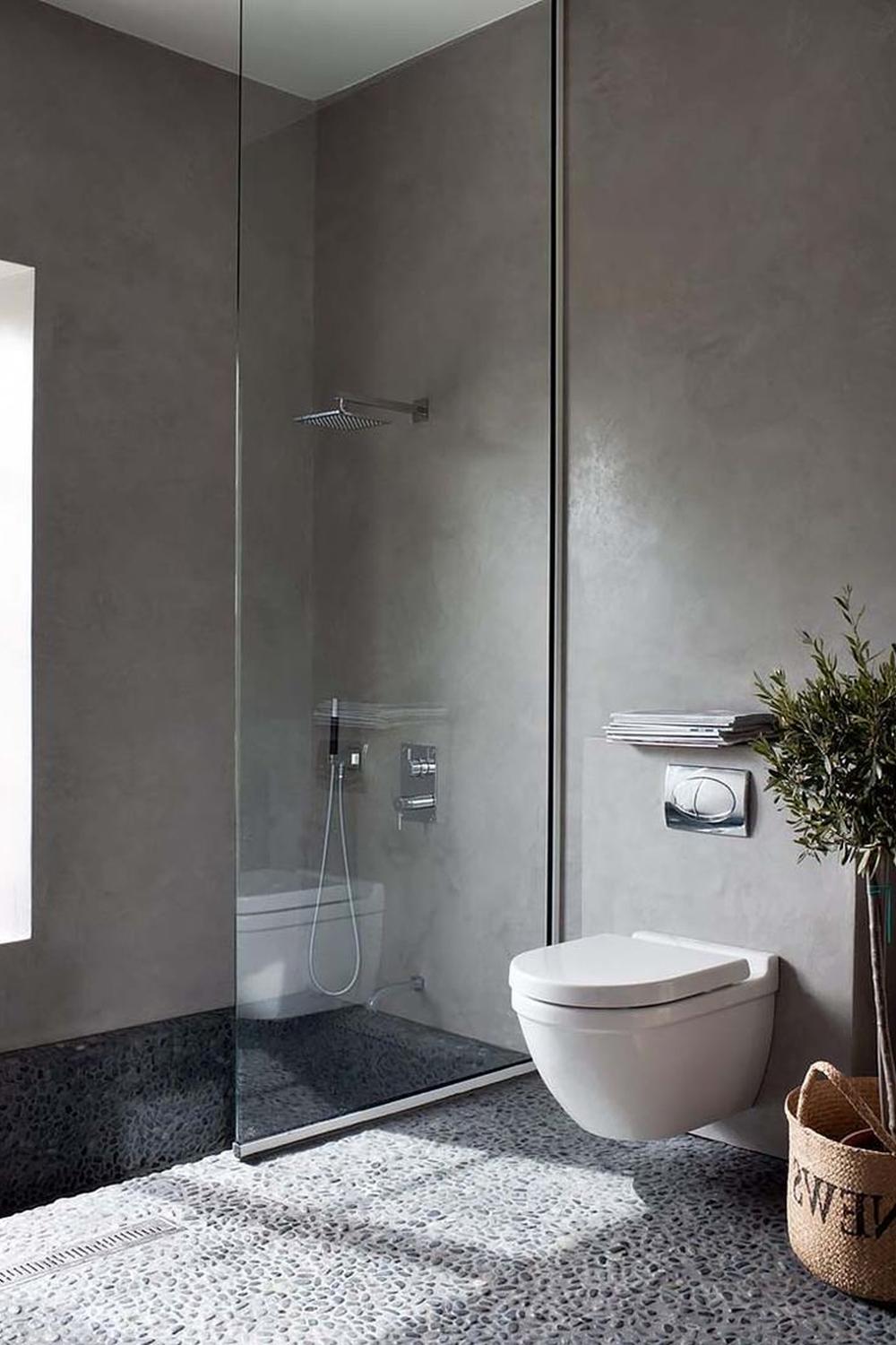 Baño minimalista con elementos de hormigón y naturaleza