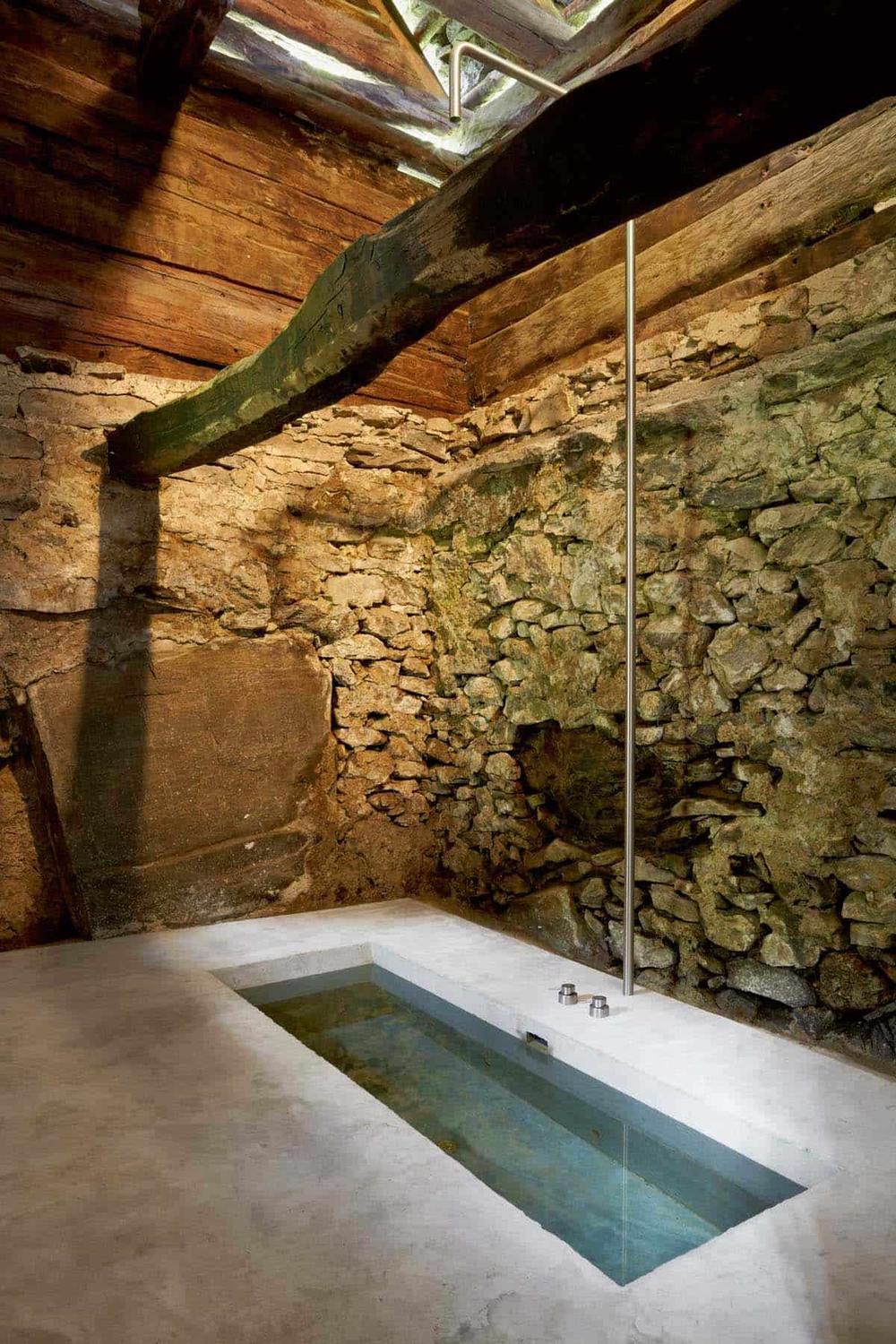 Baño rústico y moderno con hormigón y piedra