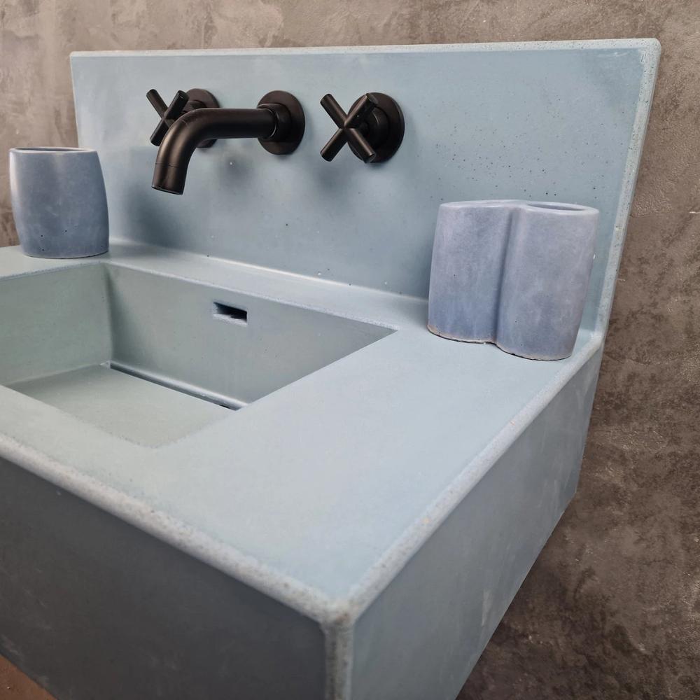 Sleek Minimalist Concrete Vanity with Integrated Sink featuring a smooth, polished blue concrete, integrated sink, and matte black faucet.