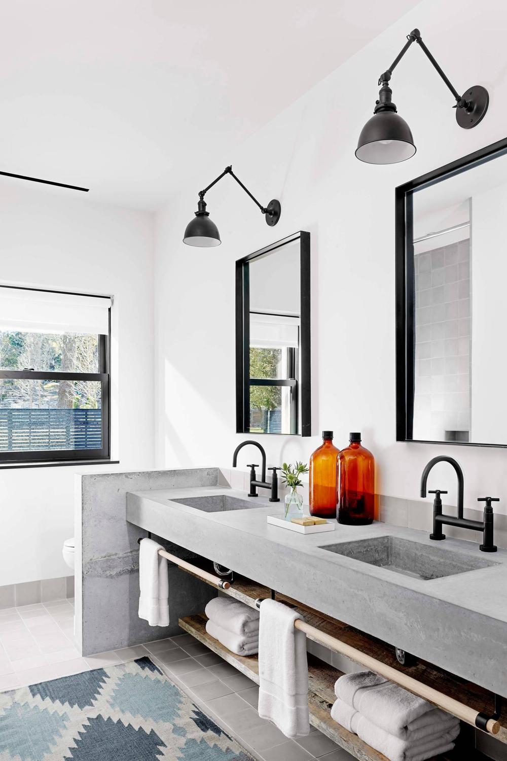 Striking Wide Concrete Vanity with Dual Sinks featuring a wide countertop, two integrated sinks, and matte black fixtures.