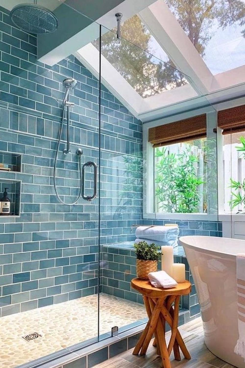 Contemporary blue bathroom with a skylight, freestanding tub, and nature elements.