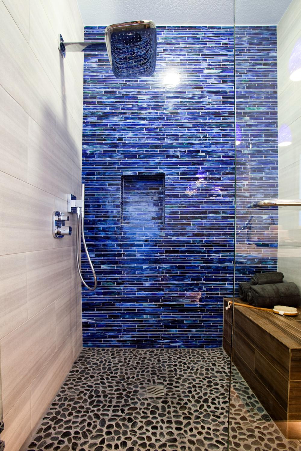 Contemporary bathroom featuring artistic wave tiles and glass shower.