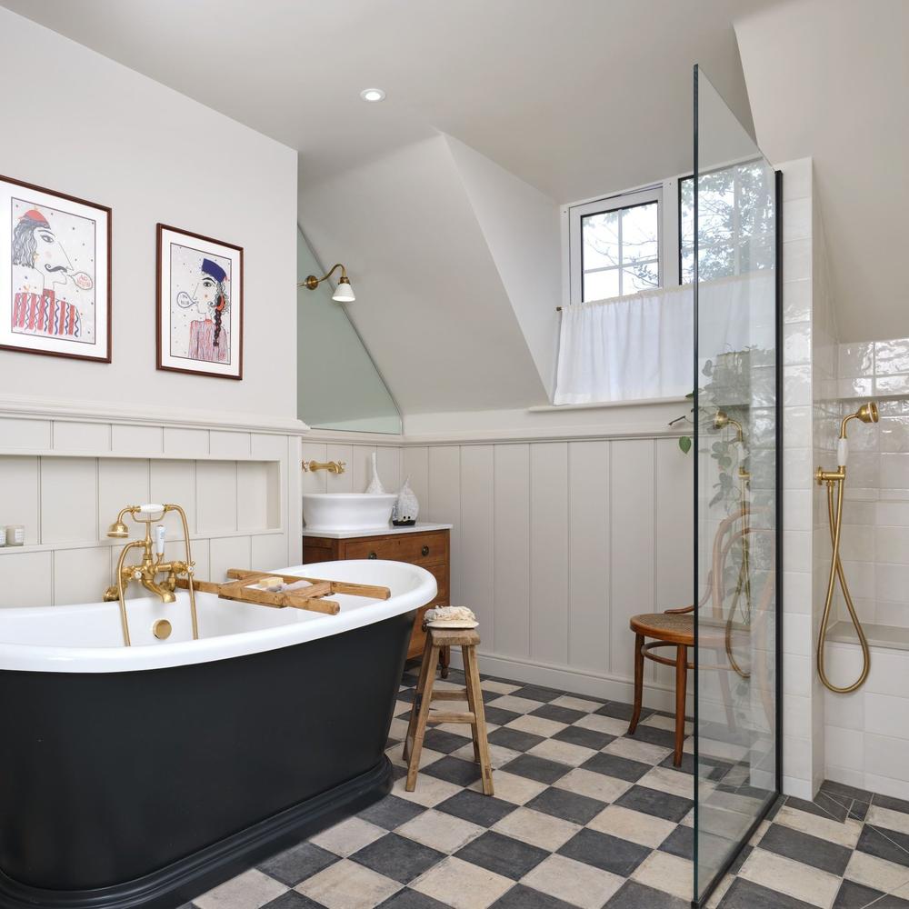 Stylish cottage bathroom showcasing luxurious bathtub and modern fixtures.