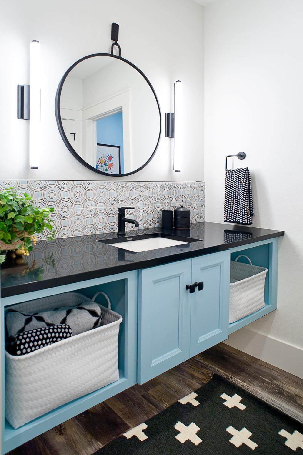 Baño moderno estilo cottage con armarios azules y encimera negra