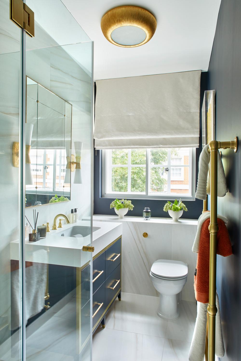 Baño cottage con armarios azules y ducha de vidrio