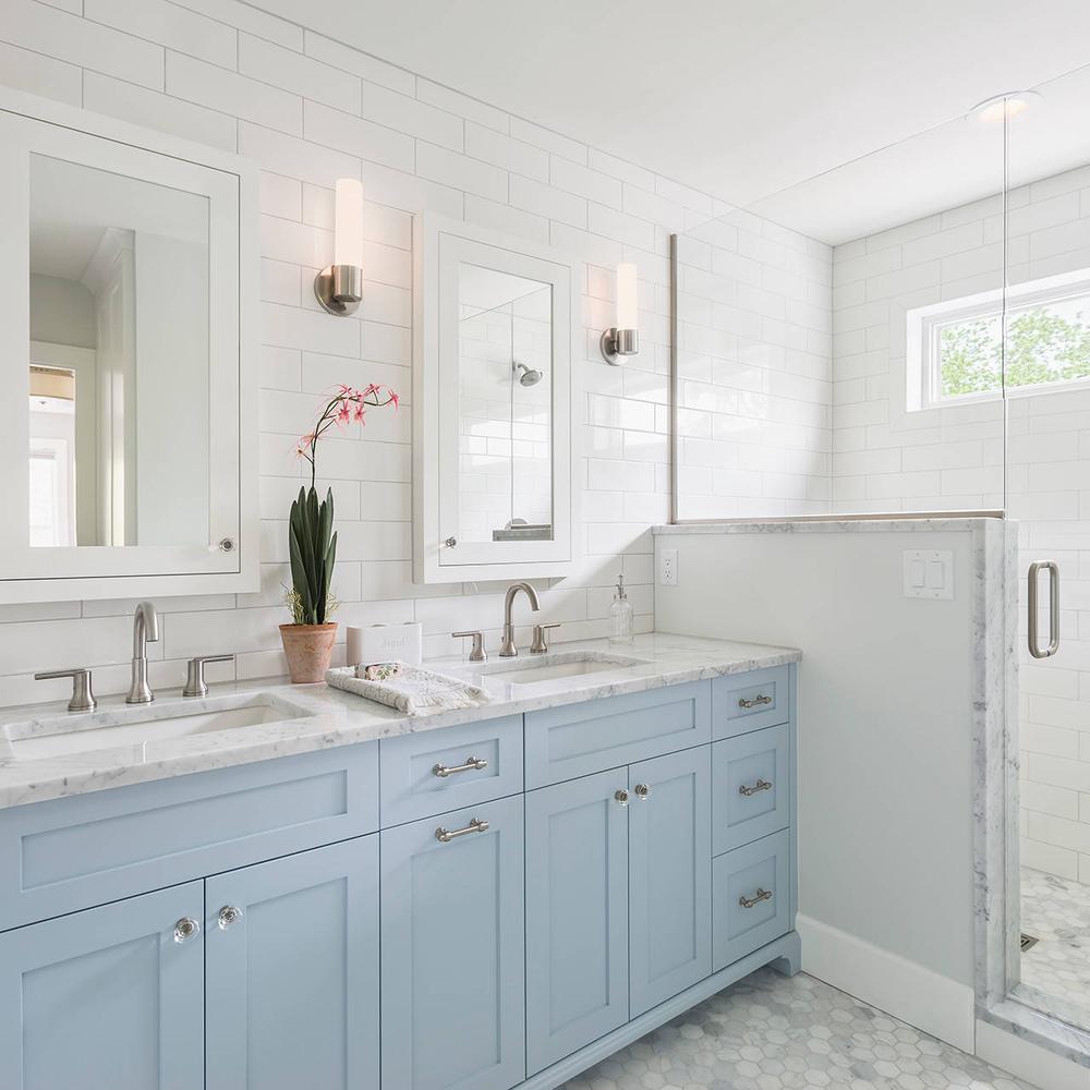 Baño contemporáneo con armarios azules y paneles de madera