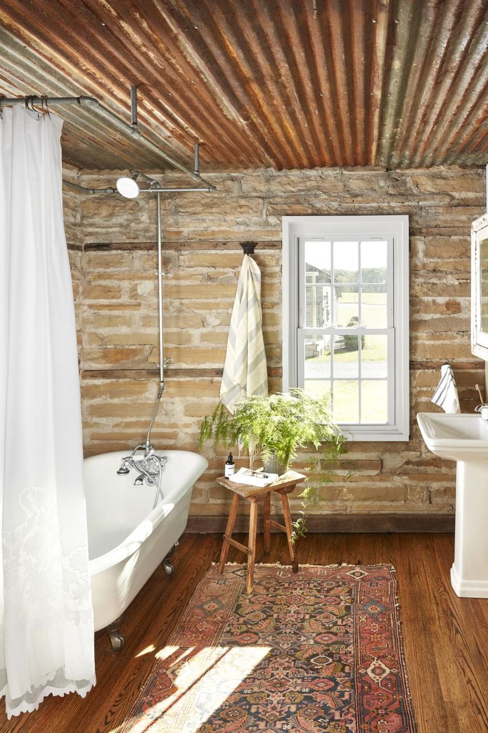 Country bathroom with industrial touches and exposed stone features