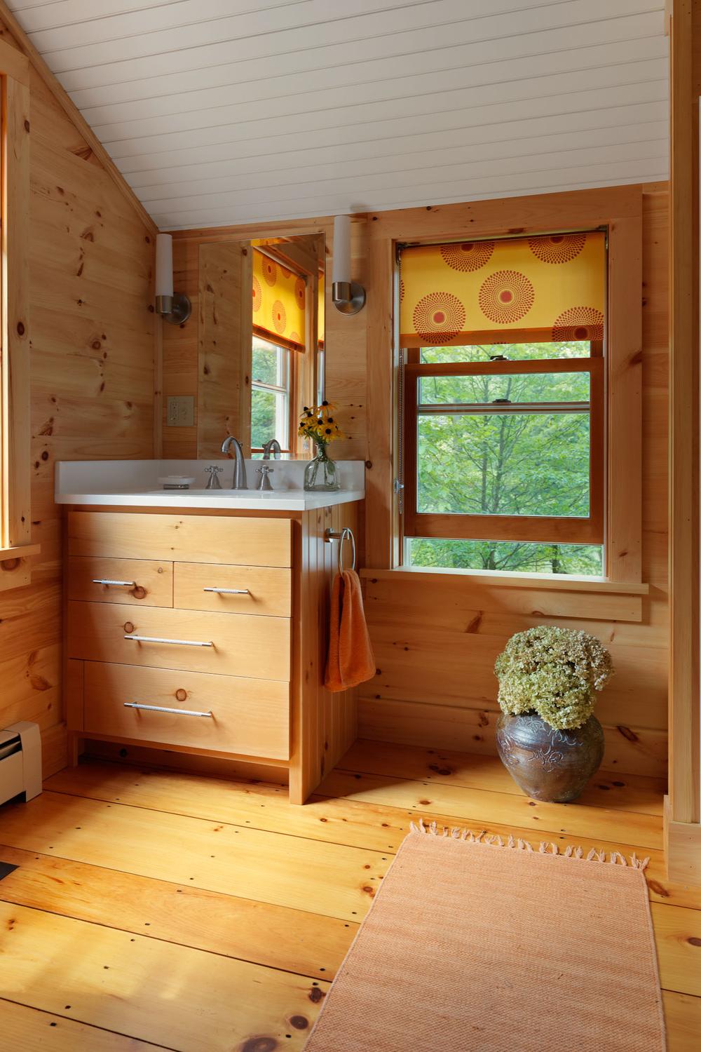 Baño acogedor con acentos de madera y luz natural.