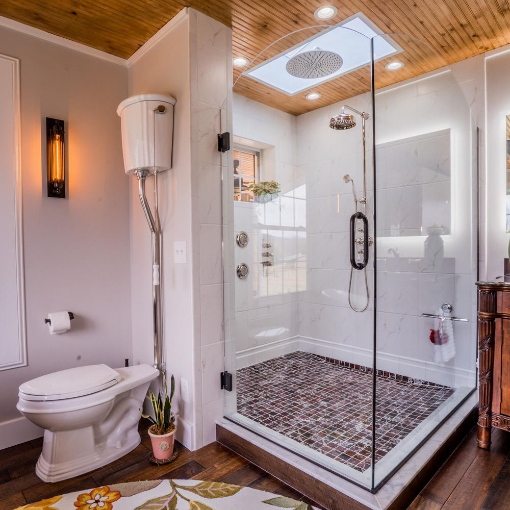 Baño con sensación rústica y moderna y ducha de lluvia.