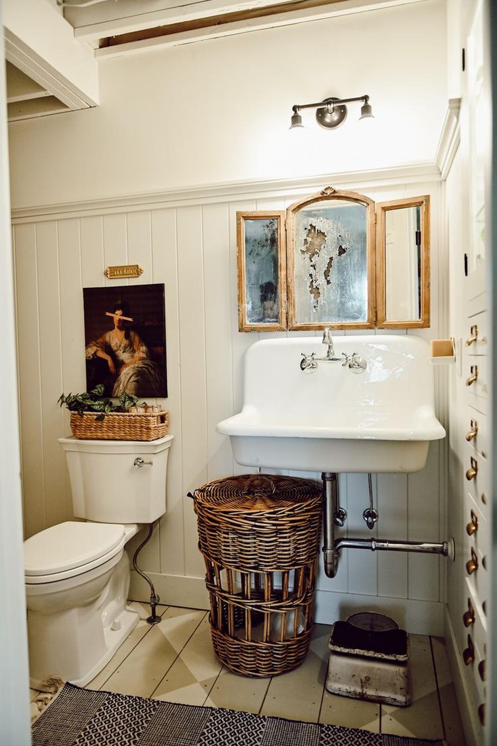 Cozy traditional bathroom featuring beige walls, black-and-white tiles, and elegant fixtures.