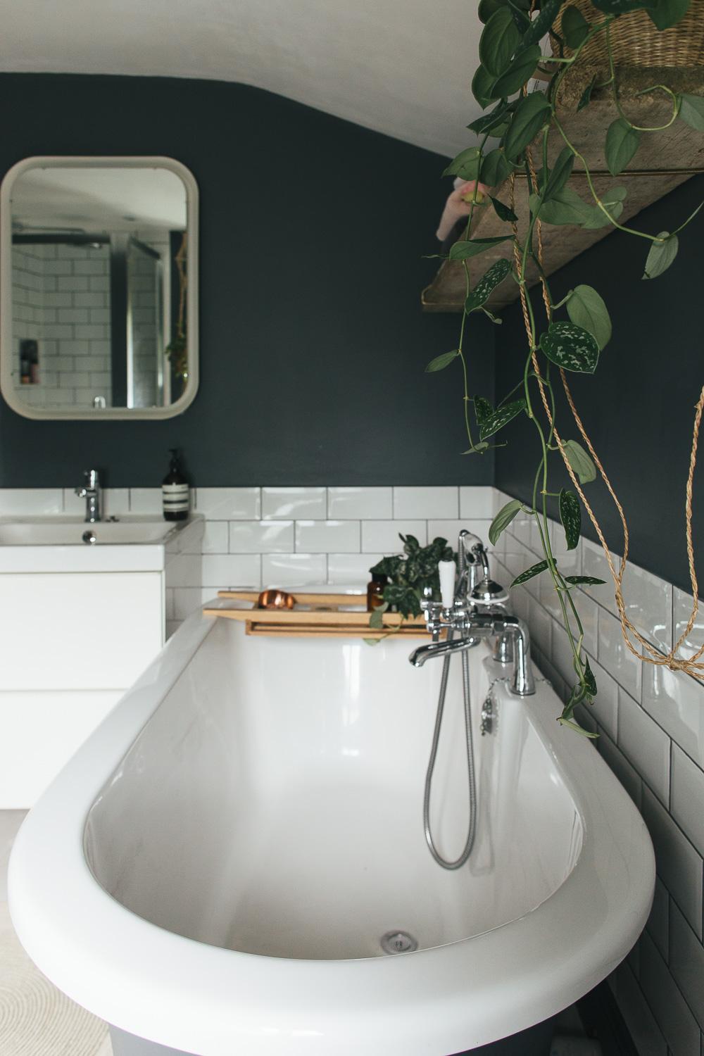 Spa-inspired dark-themed bathroom with organic elements.
