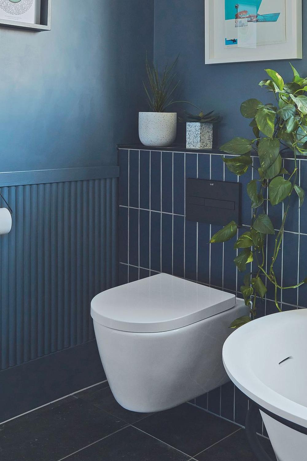 Baño moderno y lujoso con azulejos y plantas decorativas