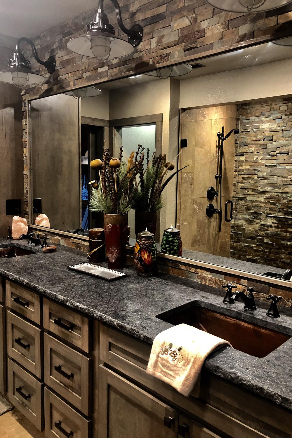Rustic-inspired bathroom featuring a wood vanity with a granite countertop and vintage-style lighting.