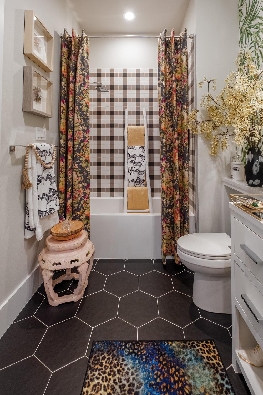 Stylish small bathroom with dark brown plaid tiles and vibrant decor accents.