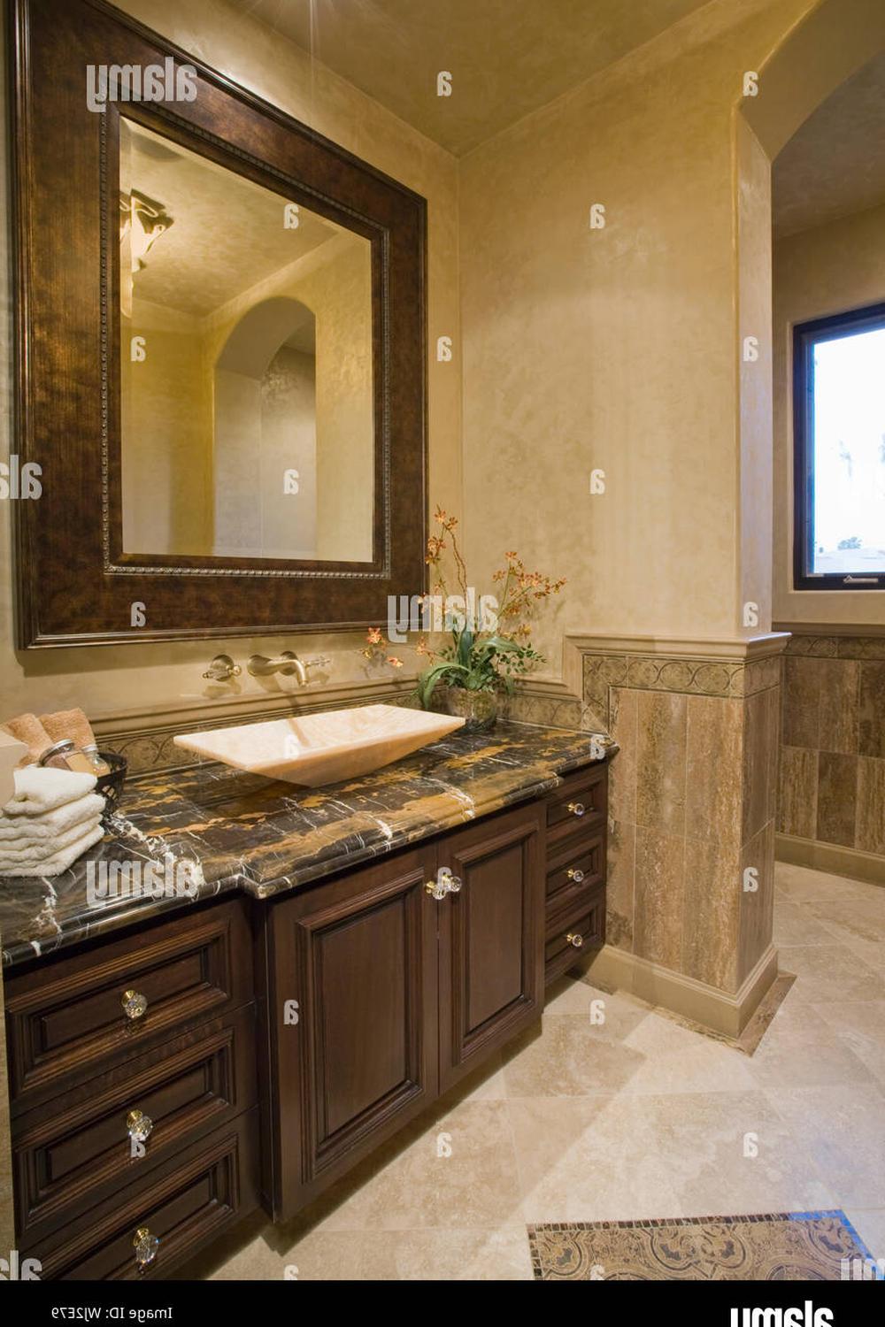 Elegant bathroom featuring dark wooden vanity and light-colored vessel sink.