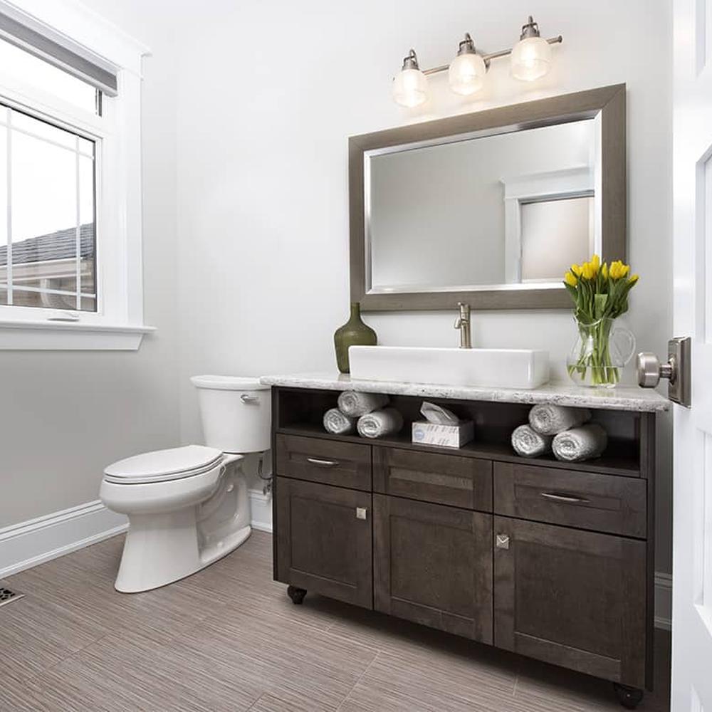 Base de madera oscura con lavabo rectangular en un baño contemporáneo