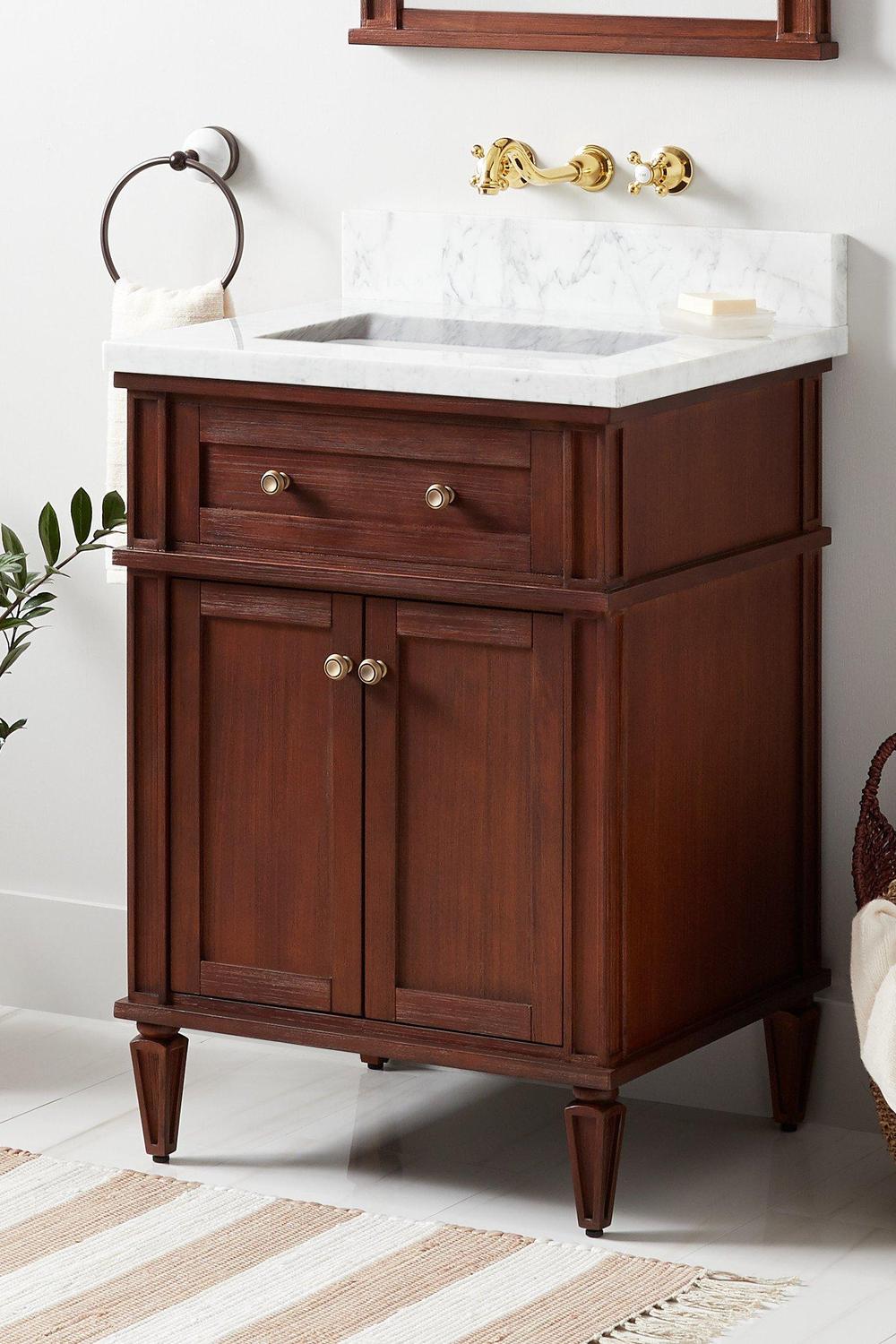 Mueble de baño oscuro con detalles clásicos y dorados
