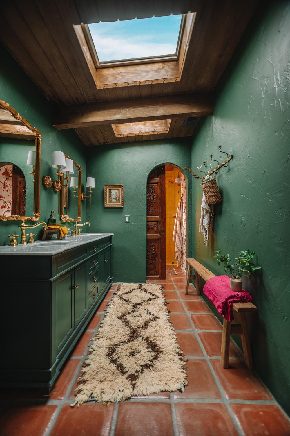 Vibrant dark green bathroom featuring bright skylights and luxurious finishes