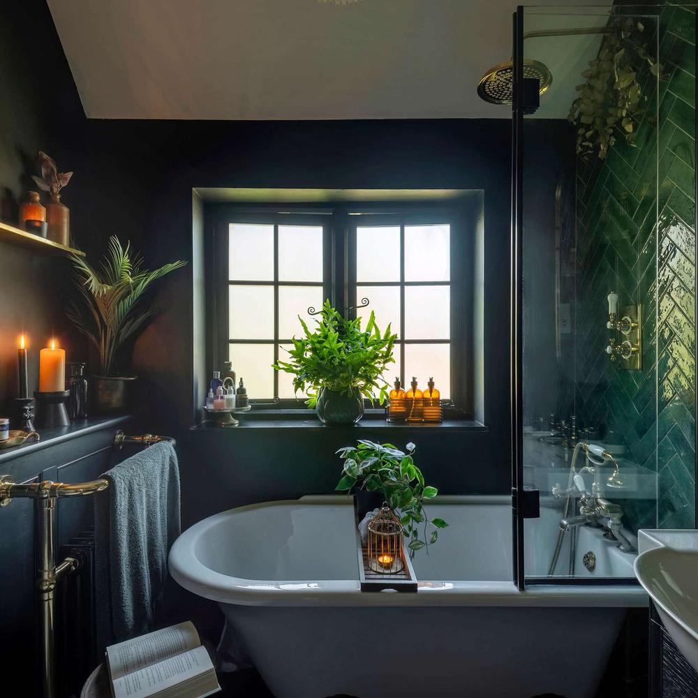 Luxurious dark green bathroom featuring black and white elements along with a classic bathtub