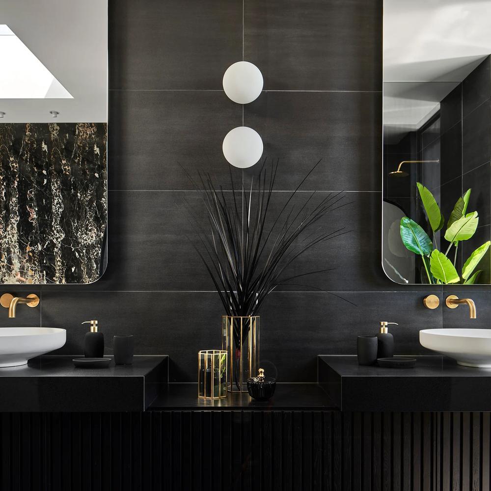 Baño moderno y oscuro con toques dorados