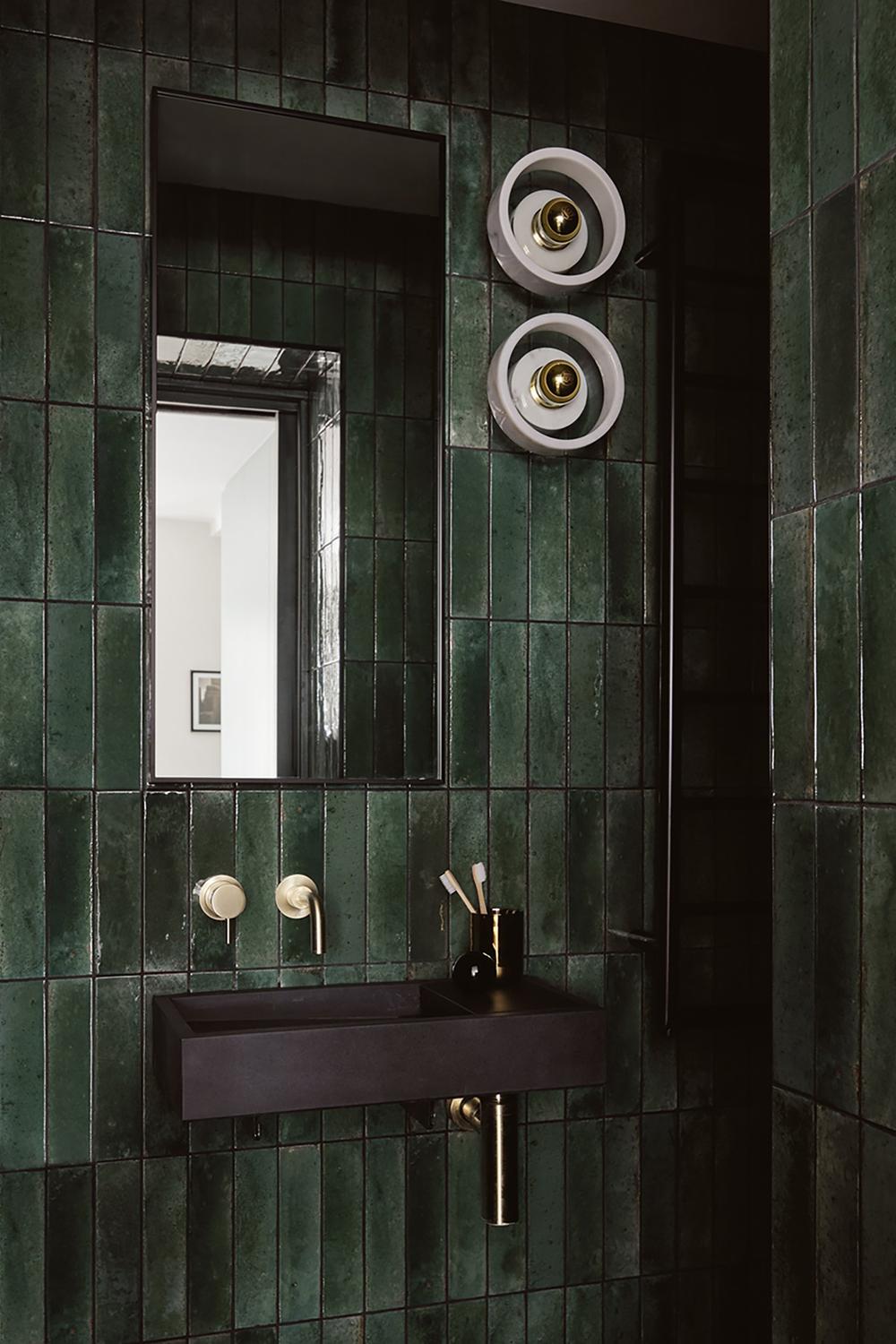 Baño en verde profundo con iluminación cálida