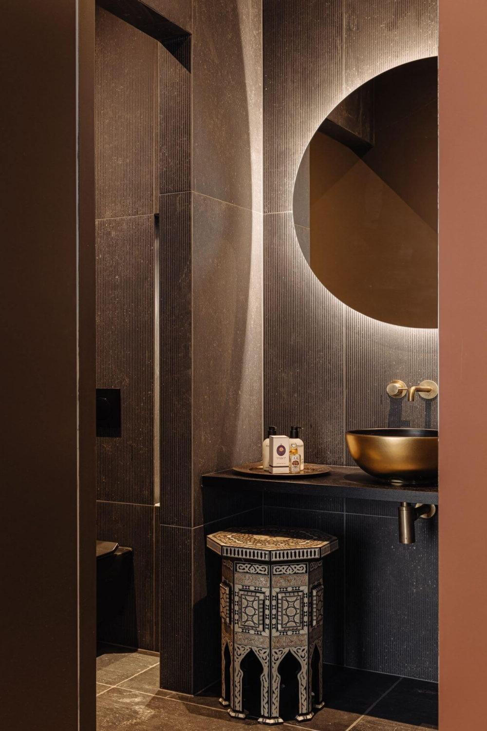 Baño gris oscuro con texturas modernas