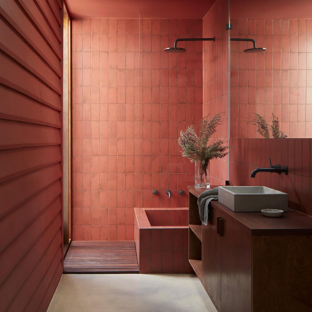 A minimalist dark red bathroom featuring sleek fixtures and contrasting colors.