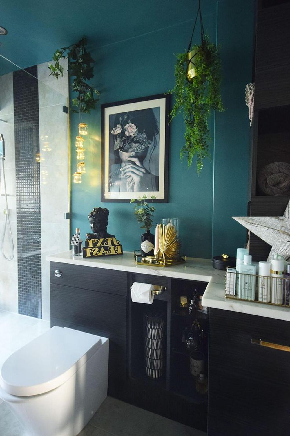 Artfully designed bathroom featuring a bold color palette with teal and black elements.