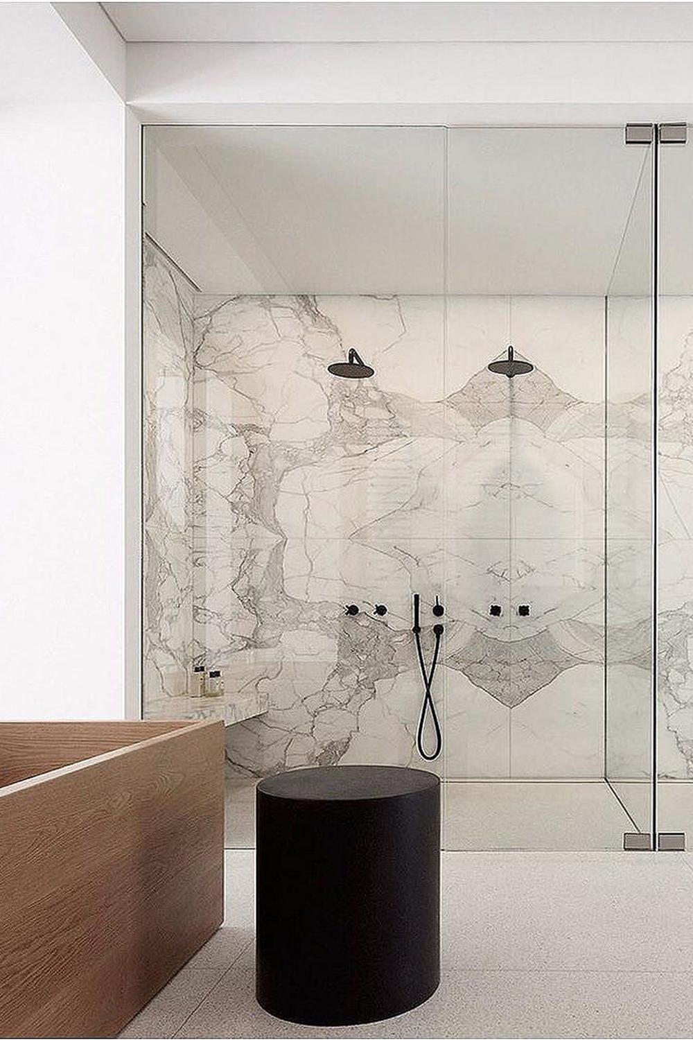 Elegant double shower bathroom with floor-to-ceiling glass walls and marble-patterned tiles.