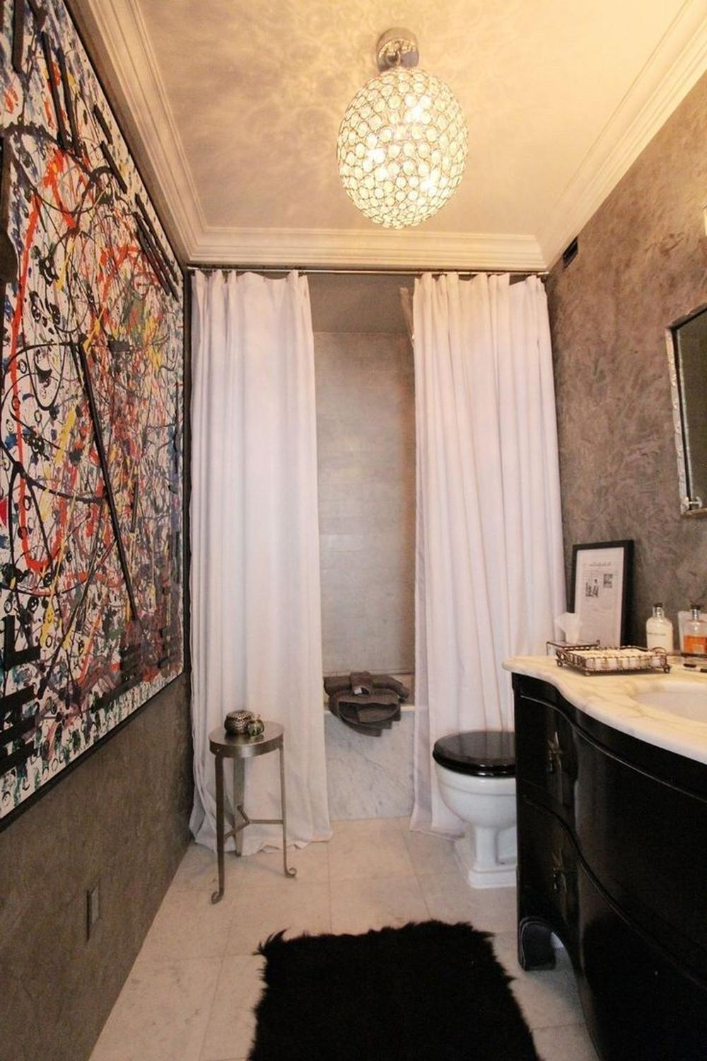 Modern minimalist bathroom featuring bright white double shower curtains harmonizing with vibrant artwork.