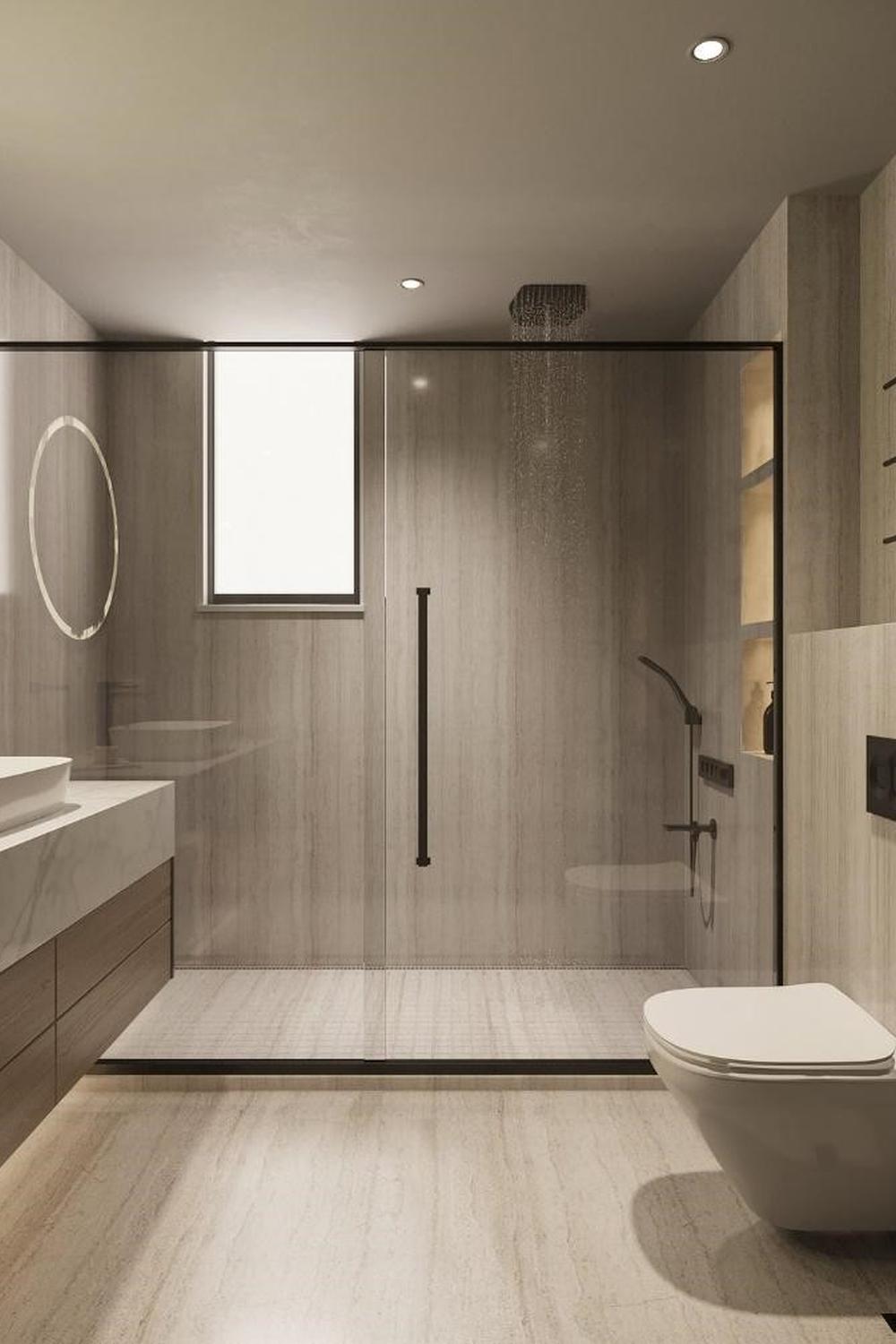 Baño minimalista con tonos grises y beige y ducha de vidrio sin marco.