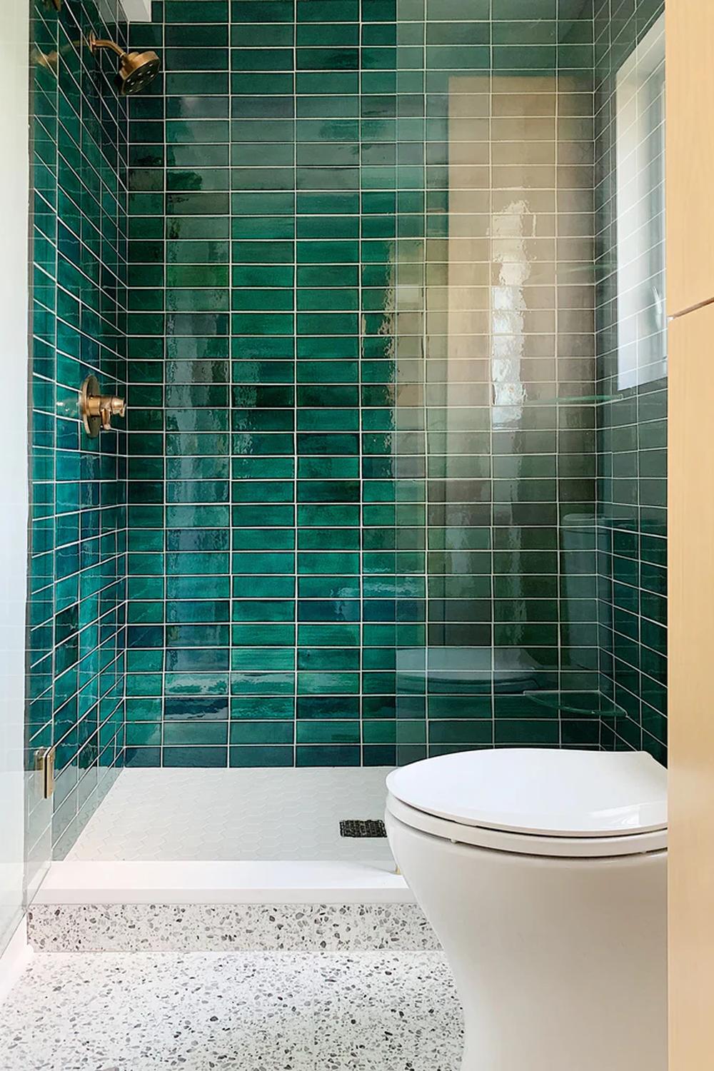 A modern bathroom featuring a vibrant emerald green shower design