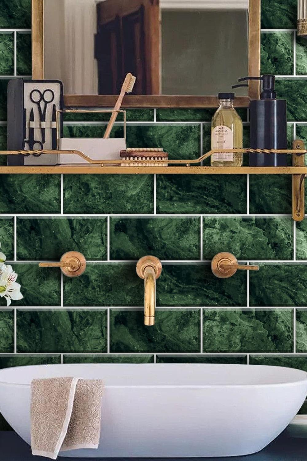 A chic bathroom featuring emerald green tile with a marble-like texture