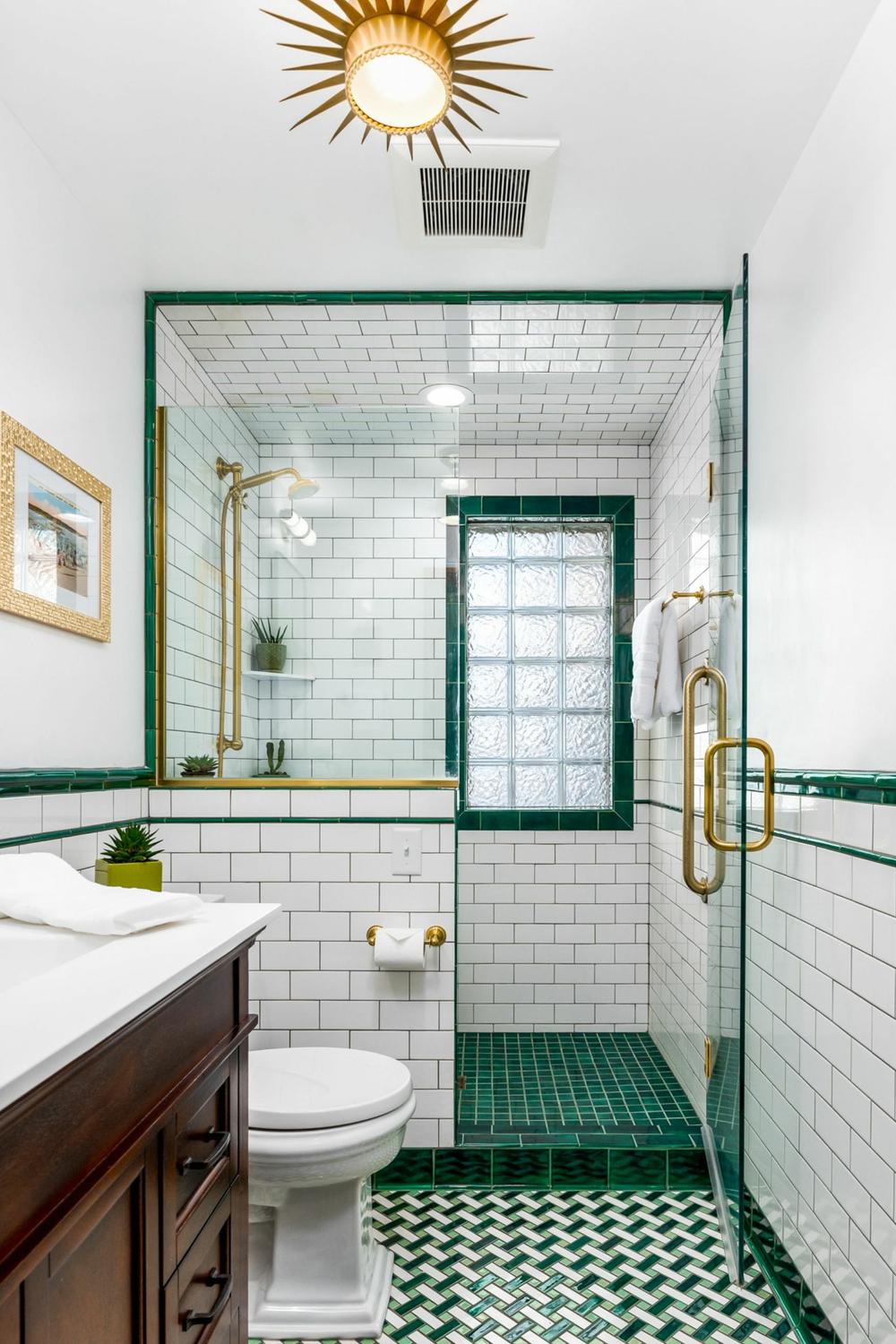 A bright bathroom featuring clean emerald green accents