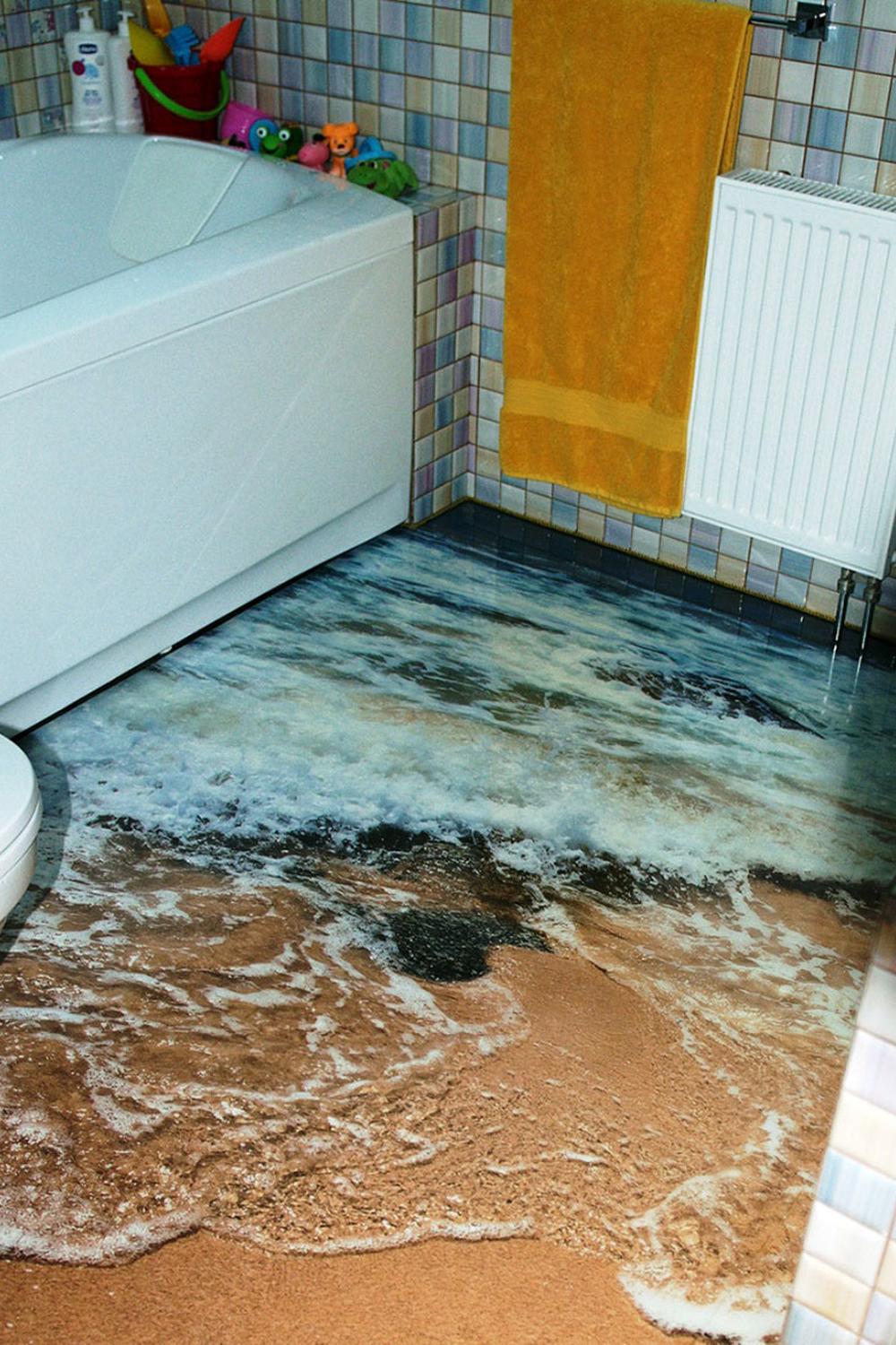 A vibrant bathroom showcasing epoxy flooring resembling a sandy beach meeting the ocean waves, creating a relaxed coastal vibe.
