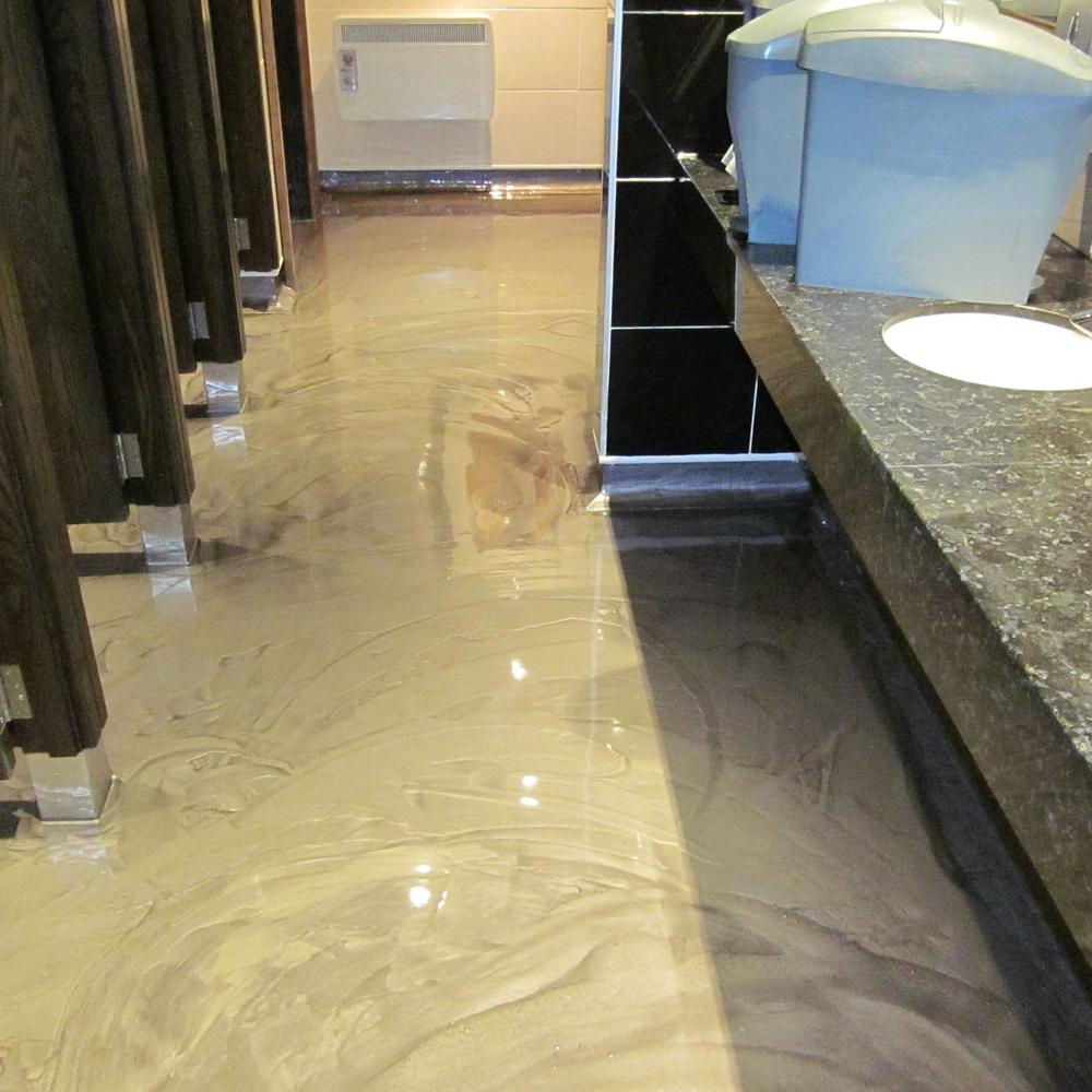 A lightly colored, glossy epoxy bathroom floor highlighting a smooth surface and clean lines.
