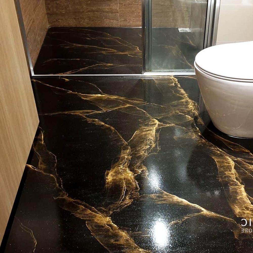 Luxurious bathroom flooring designed to mimic the look of natural marble, featuring deep blacks and golden veins.