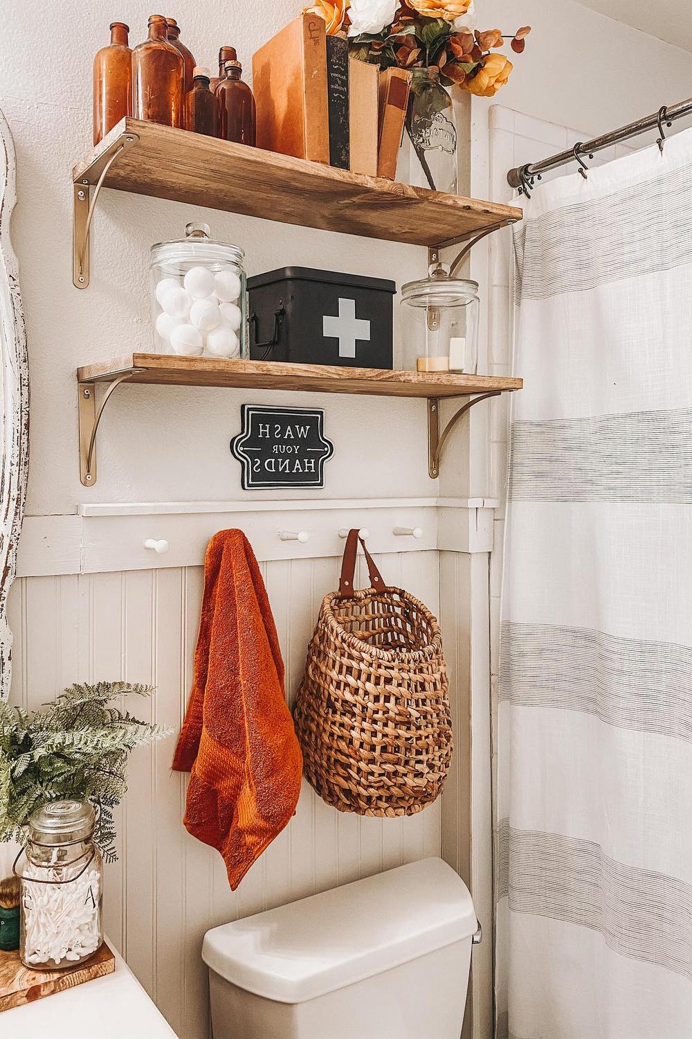 Baño rústico y moderno decorado para otoño con estantes de madera